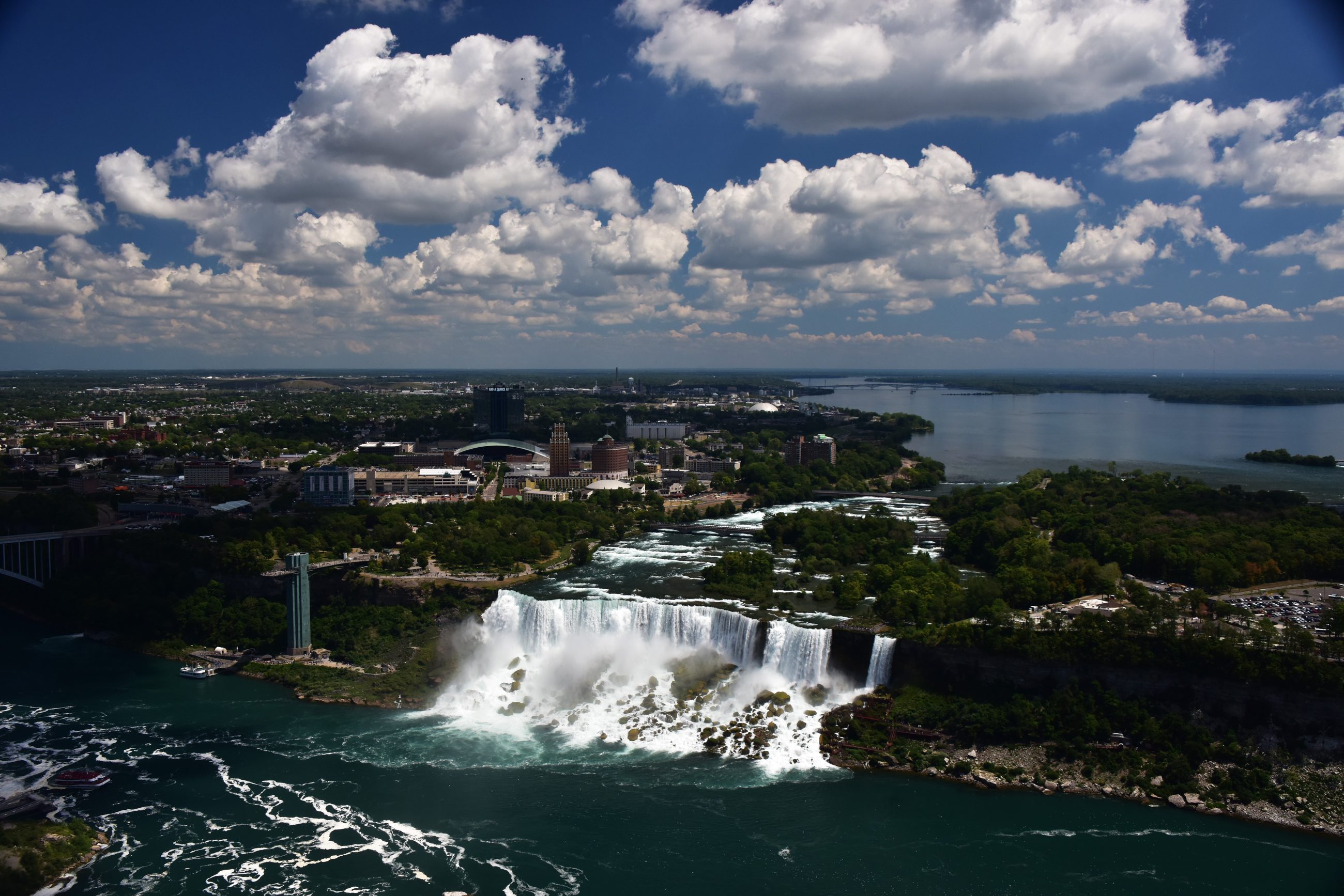 Aerial view of Niagara Falls and the surrounding downtown, with the American Falls, the Niagara River and the city beyond